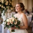 Claudua Secara junto a su ramo de rosas y eucalipto en una celebración nupcial